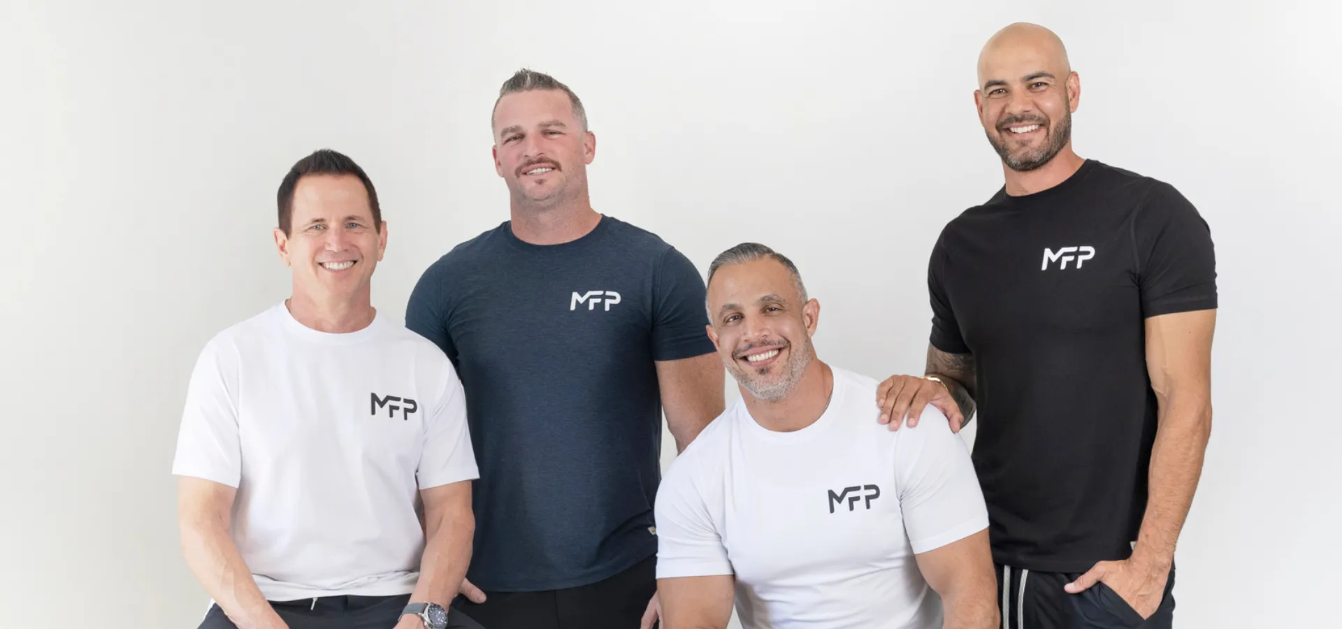 The four Mind Pump Podcast hosts in Mind Pump t-shirts